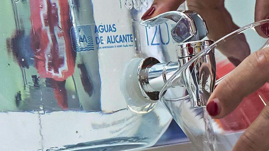 Una mujer se sirve agua del grifo en un hotel de Alicante.