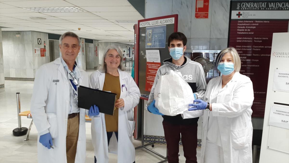 Personal del Hospital Lluís Alcanyís, junto a uno de los usuarios del servicio de entrega de efectos personales a pacientes