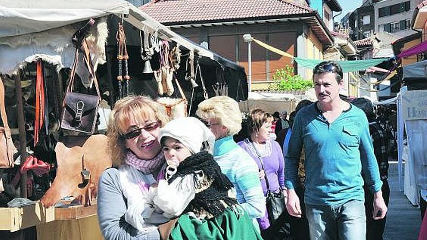 Visitantes entre los puestos del mercado tradicional de La Flor, en el barrio lenense de La Caleya.