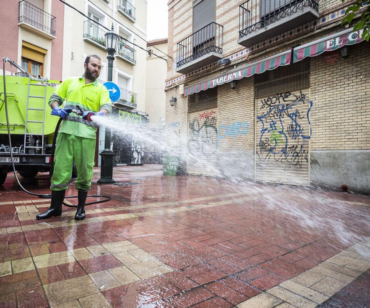 Un operario de FCC limpia con agua a presión una calle del centro de Zaragoza.  | EL PERIÓDICO