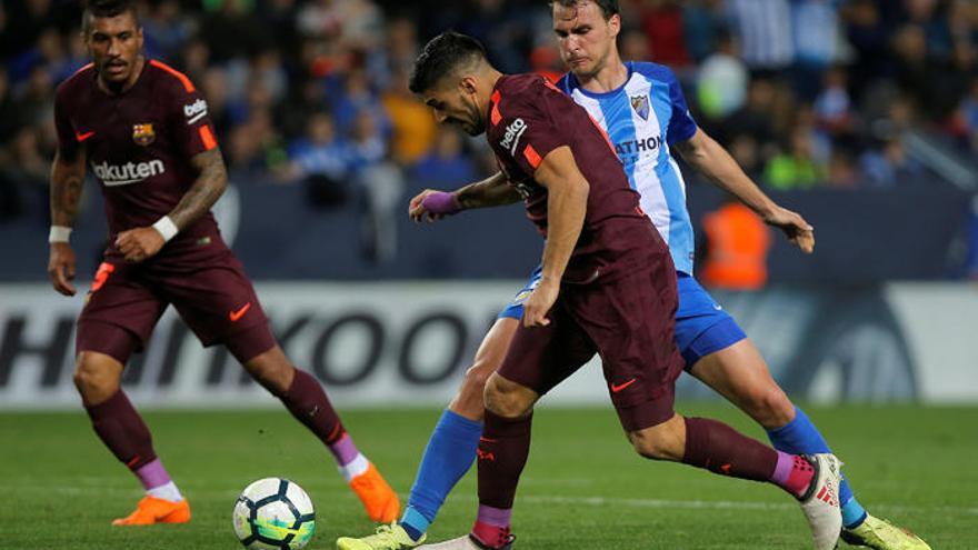 Ignasi Miquel, central del Málaga CF, en un lance con el delantero del FC Barcelona Luis Suárez, el sábado en Martiricos.