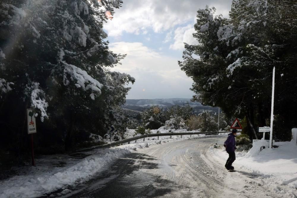 Un joven practicando snowboard por la carretera de les Planes.