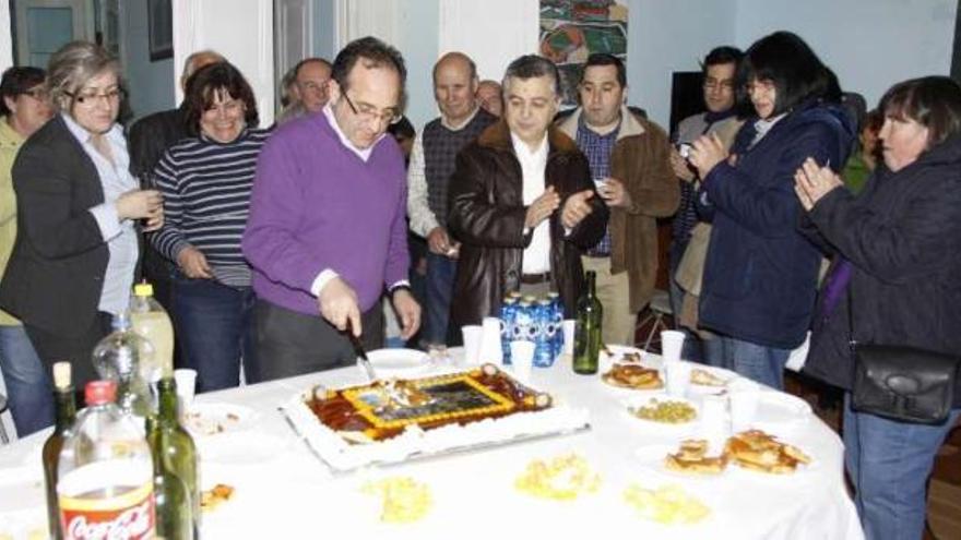 José Enrique Sotelo corta la tarta con la imagen del yacimiento de O Facho en la fiesta celebrada ayer en la sede del Partido Popular con motivo de la celebración de los Pepes.  // Carmen G.