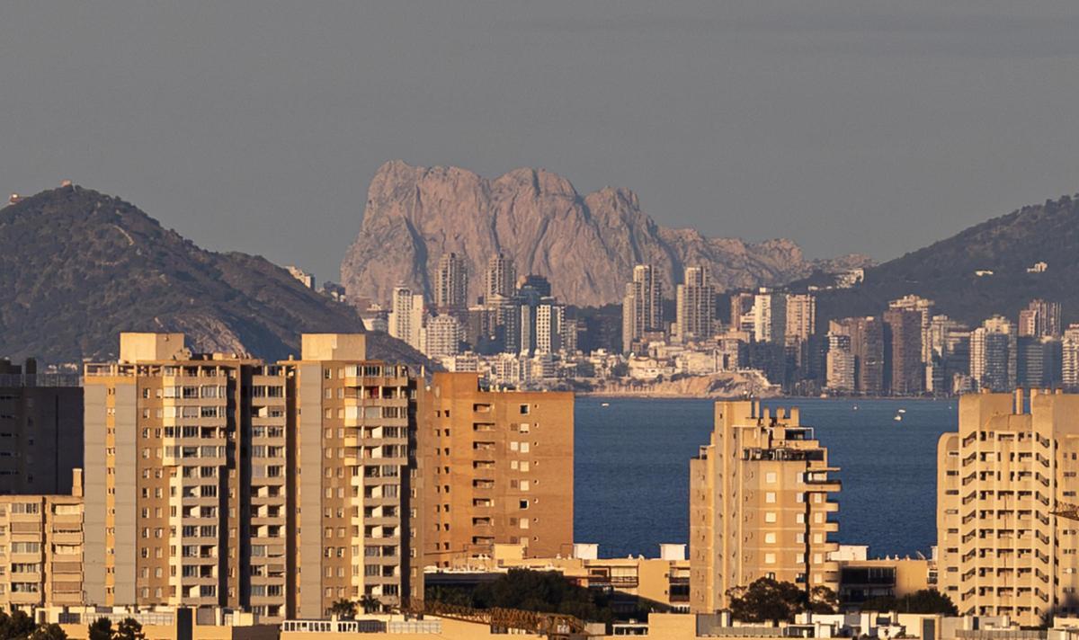 Una vista del Peñón de Ifach desde Benidorm, con los bloques de apartamentos en primer término.