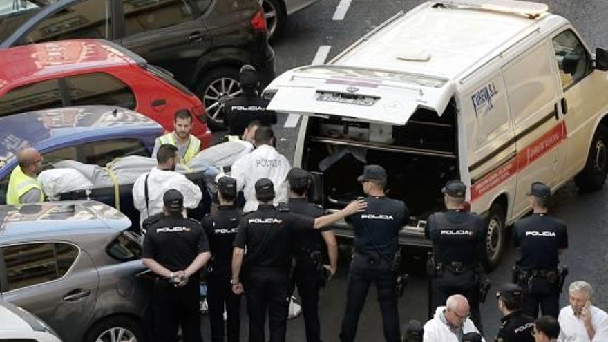 Funcionaris judicials s&#039;emporten un dels cadàvers del lloc dels fets.