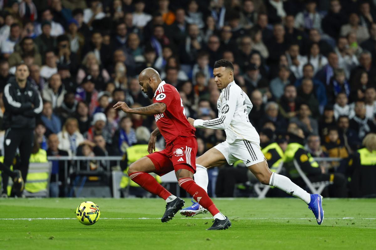 MADRID, 20/12/2025.- El defensa brasileño del Sevilla, Marcao (i), conduce el balón ante el delantero francés del Real Madrid, Kylian Mbappé, durante el encuentro de la jornada 17 de LaLiga entre Real Madrid y Sevilla FC celebrado este sábado en el estadio Santiago Bernabéu, en Madrid. EFE / Juanjo Martín.