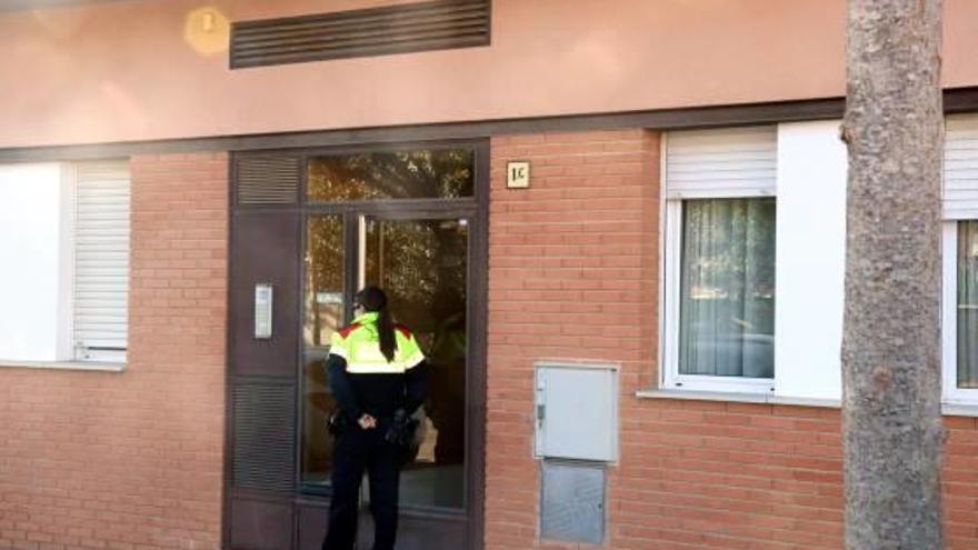 Una agent dels Mossos, a la porta de l&#039;edifici de Torroella de Montgrí on es van produir els fets.