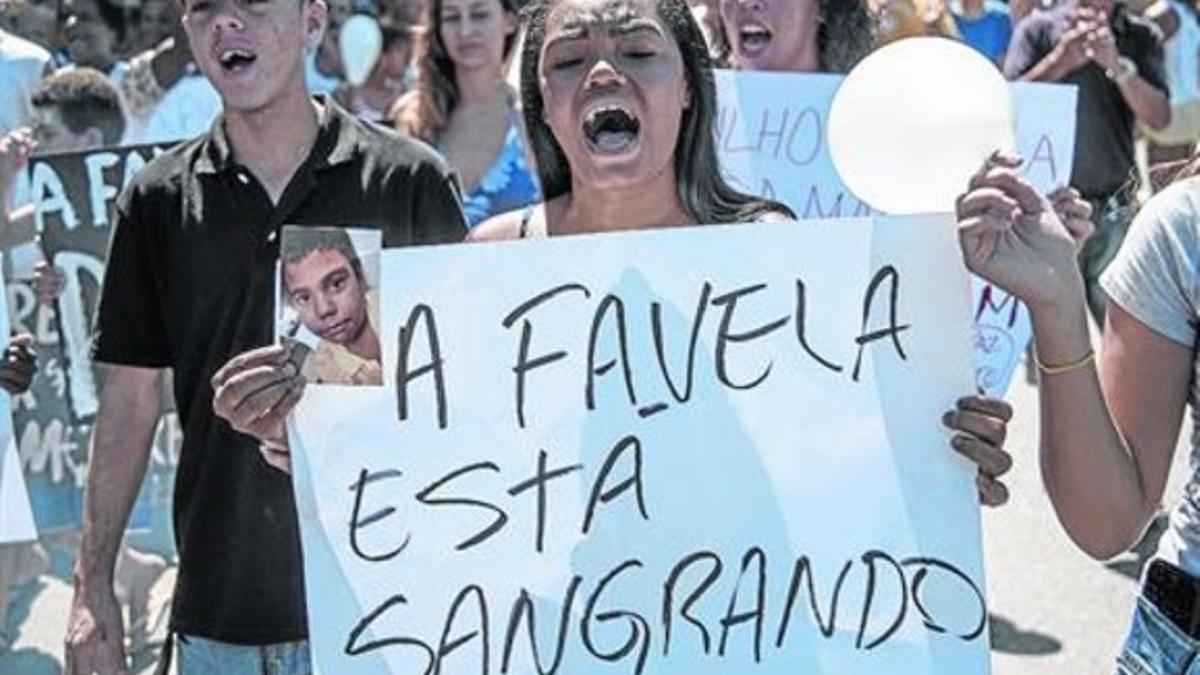 Una mujer participa en la 'marcha por la paz' en la favela Alemao tras la muerte de un niño por la policía.