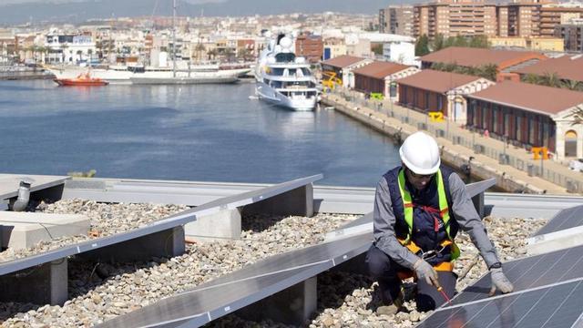 Un treballador instal·la plaques fotovoltaiques al port de Tarragona.
