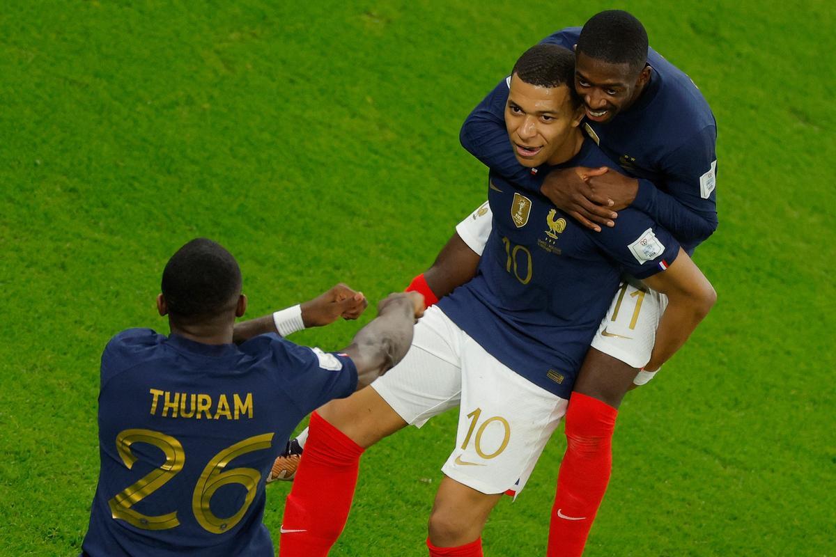 Kylian Mbappe (C) celebra con el delantero francés #26 Marcus Thuram (L) y el delantero francés #11 Ousmane Dembele después de marcar el segundo gol de su equipo en la Copa Mundial Qatar 2022 entre Francia y Polonia