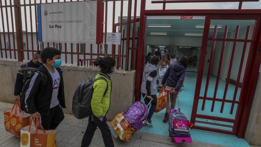 Varios niños entran por la puerta de un colegio de Elche, en una imagen de abril. | ANTONIO AMORÓS
