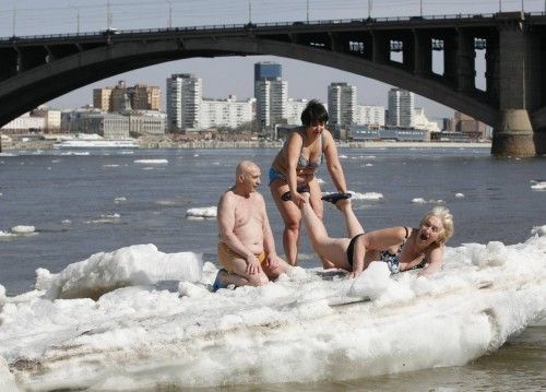 Members of the Cryophil winter swimmers club sunbathes as they sit on an ice floe on the Yenisei River in Krasnoyarsk