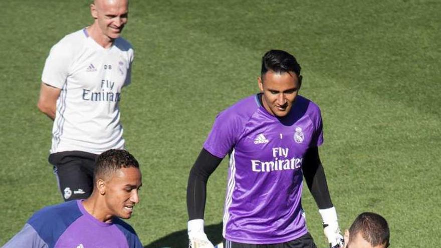 Benzema trata de evitar un pase de Danilo bajo la mirada de Keylor Navas durante el entrenamiento ayer del Madrid en Valdebebas.