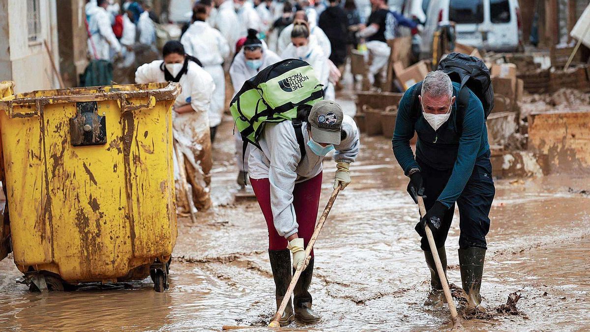 Voluntarios retirando barro en Paiporta, tres semanas después de la dana.