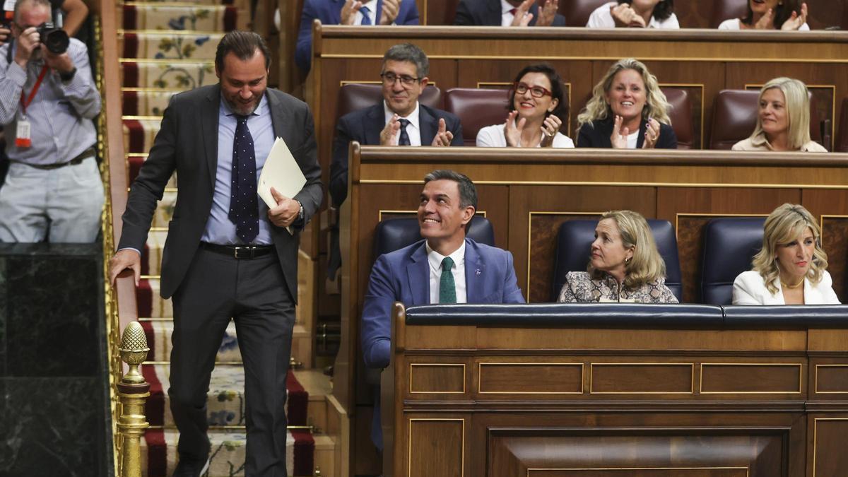 Óscar Puente pasa al lado de Pedro Sánchez antes de dar la réplica a Alberto Nuñez Feijóo en el debate de investidura.