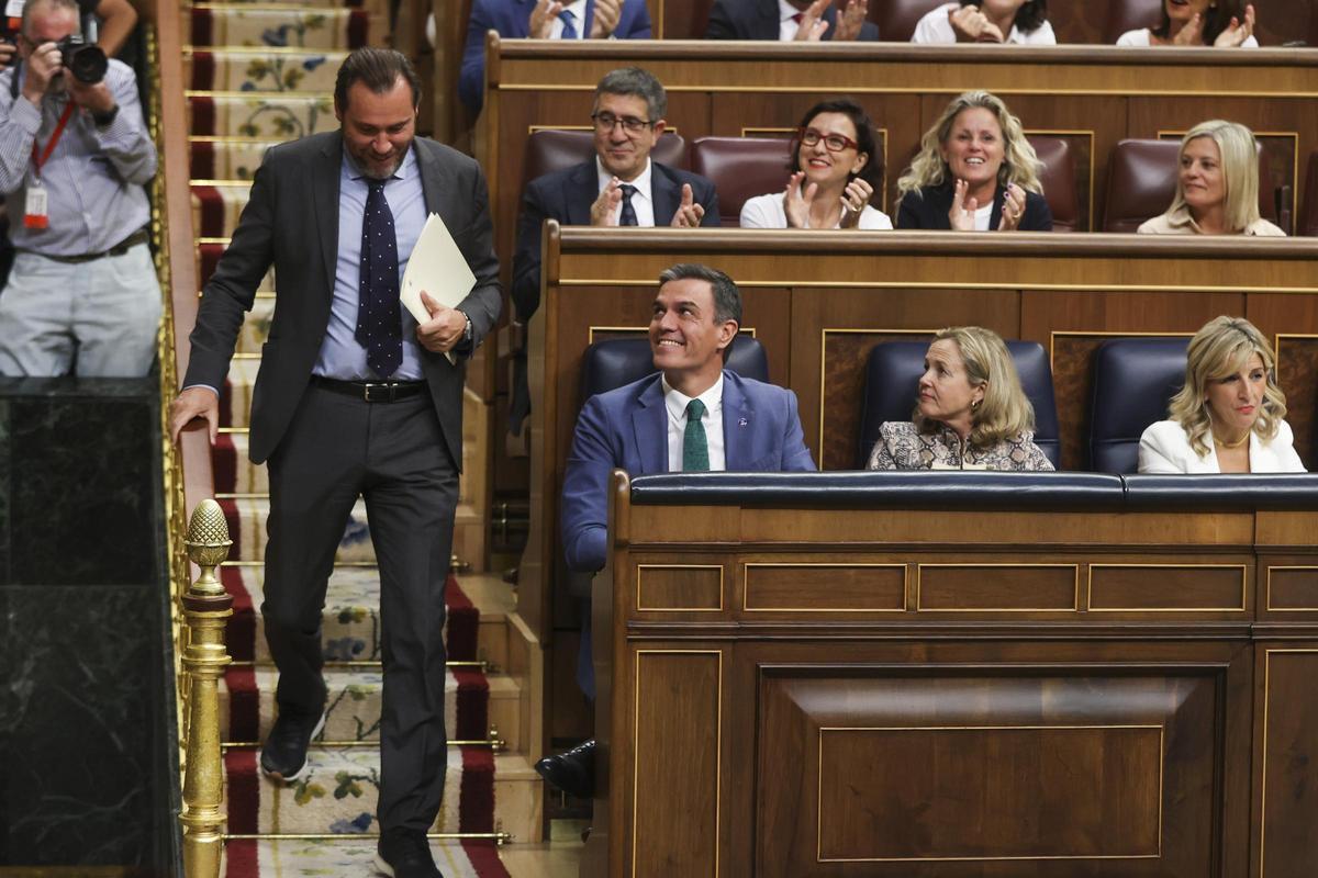 Óscar Puente pasa al lado de Pedro Sánchez antes de dar la réplica a Alberto Nuñez Feijóo en el debate de investidura.