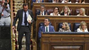 Óscar Puente pasa al lado de Pedro Sánchez antes de dar la réplica a Alberto Nuñez Feijóo en el debate de investidura.