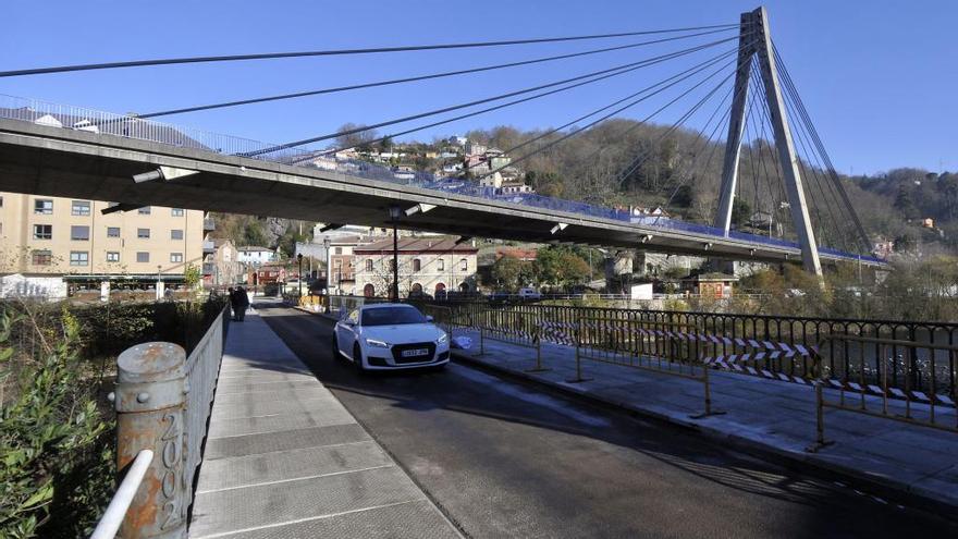 Un coche circulando por el puente viejo de Sama.