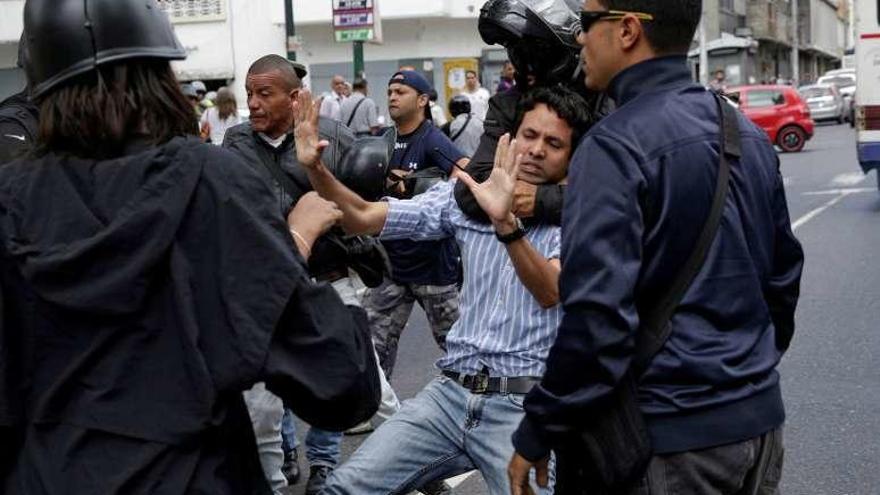 Un policía reduce a un opositor. // Reuters