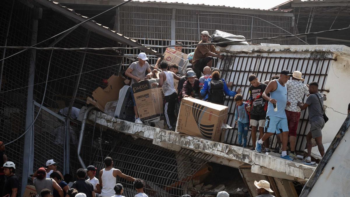 Personas saquean un establecimiento comercial este jueves, en Catia La Mar.