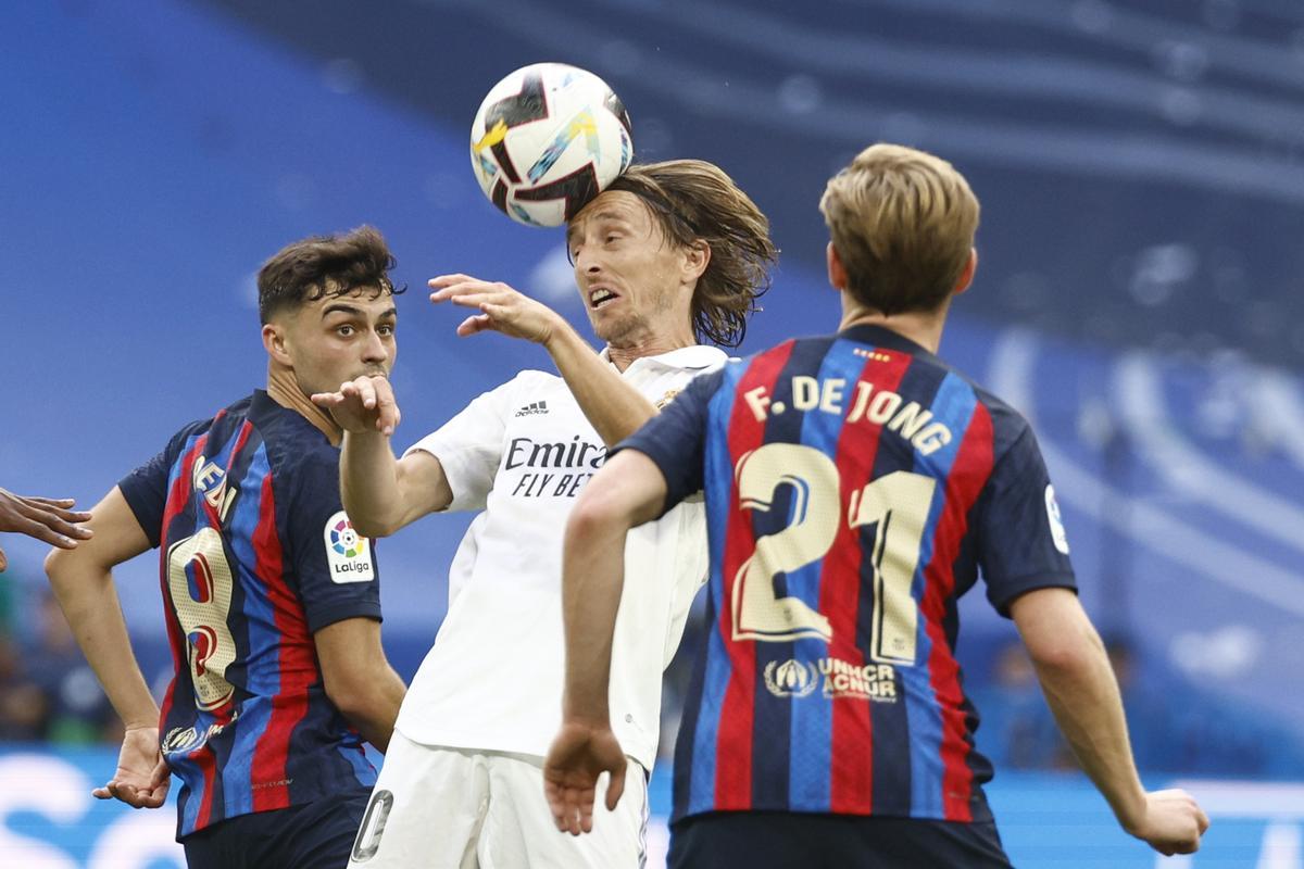 MADRID, 16/10/2022.- Los centrocampistas del FC Barcelona Pedri (i) y Frenkie de Jong (d) defienden al centrocampista del Real Madrid Luka Modrić (c) durante el partido de la novena jornada de Liga que Real Madrid y FC Barcelona disputan este domingo en el estadio Santiago Bernabéu de Madrid. EFE/ Rodrigo Jiménez