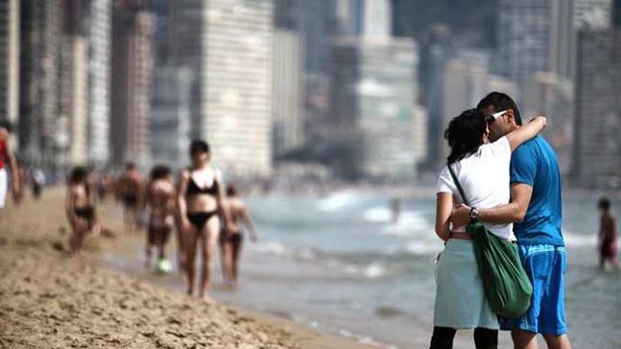 Una pareja pasea por la playa de Levante.