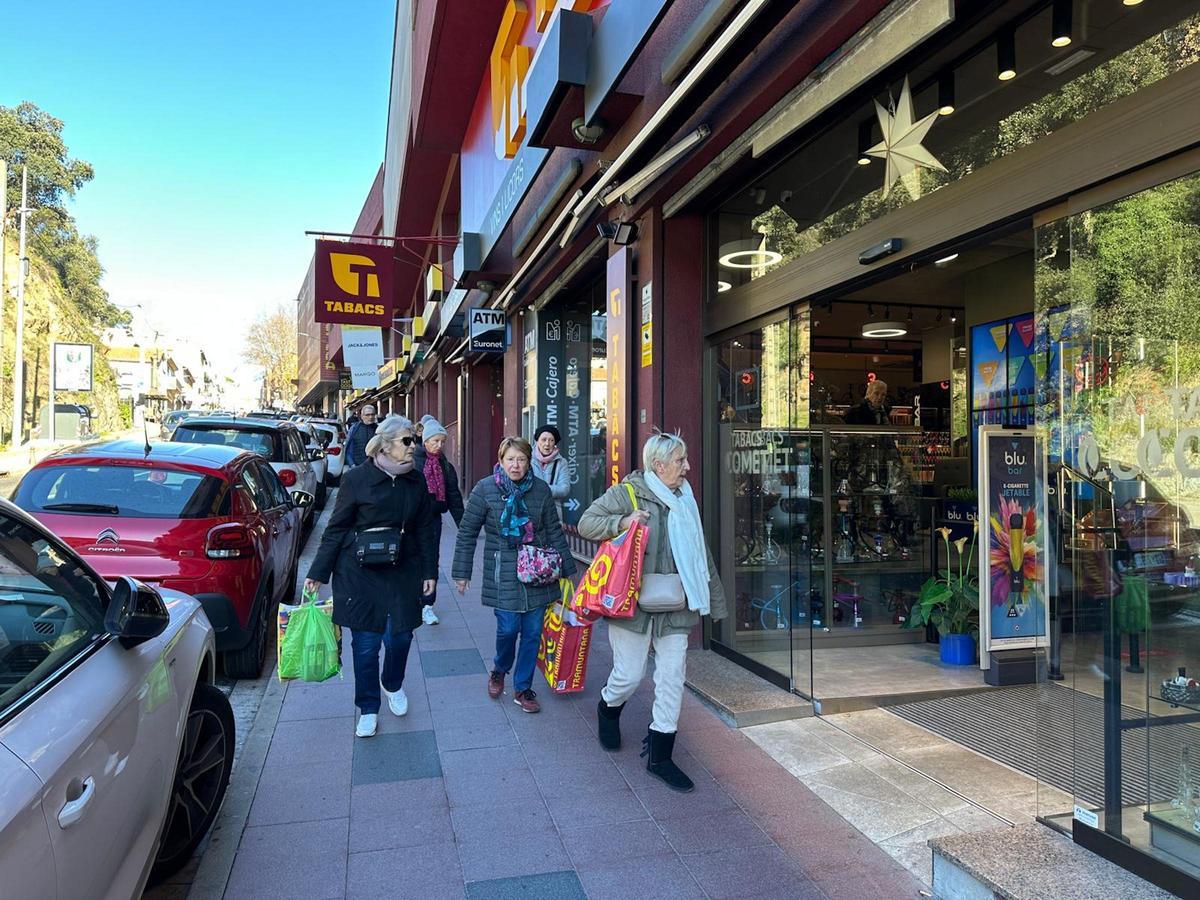 Unes clientes a punt d'entrar en un comerç del Portús.