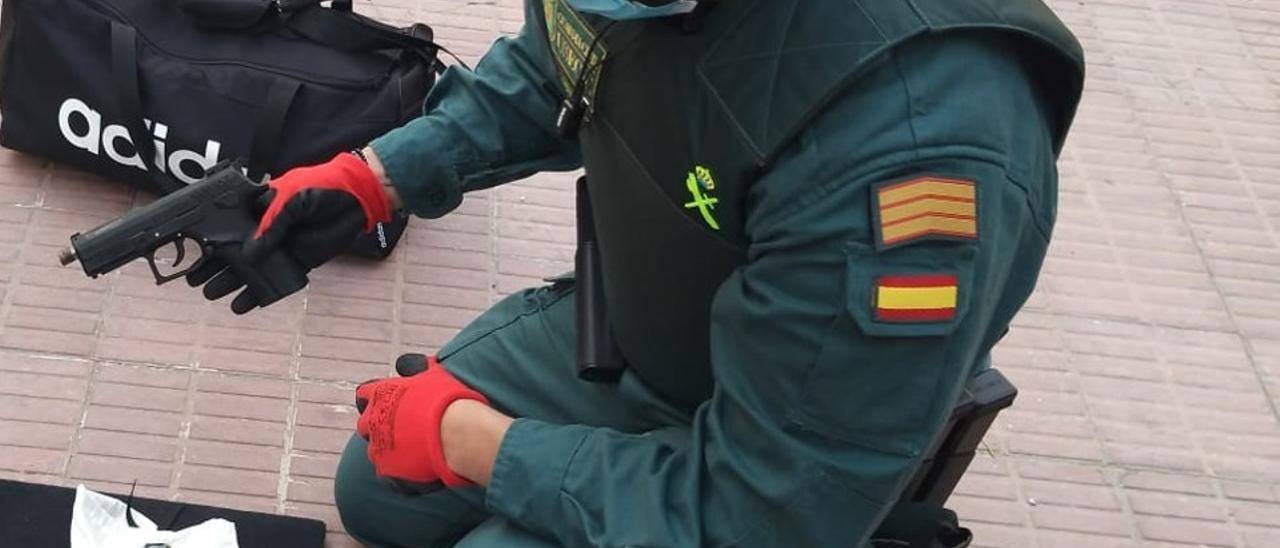 Un agente examinando el arma incautada en un control en la autovía A-31 a la altura de Villena.