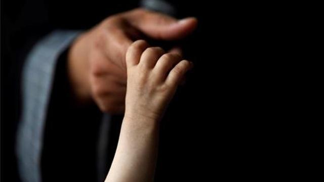 Una sanitaria da la mano a un niño con desnutrición en un centro médico de la localidad de Bani Qais en la provincia de Hajjah, Yemen