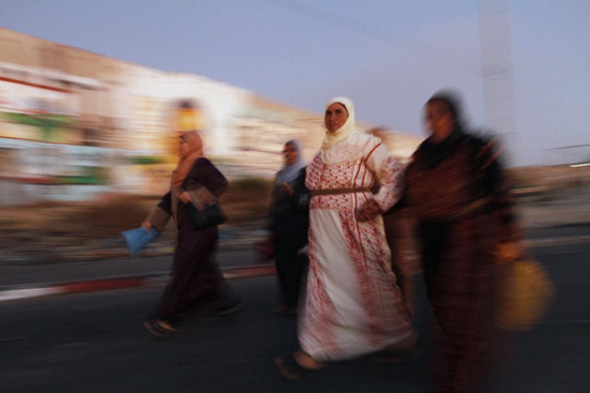 Dones palestines passegen al costat de la controvertida barrera que separa Cisjordània d’Israel, a Ramal·la.