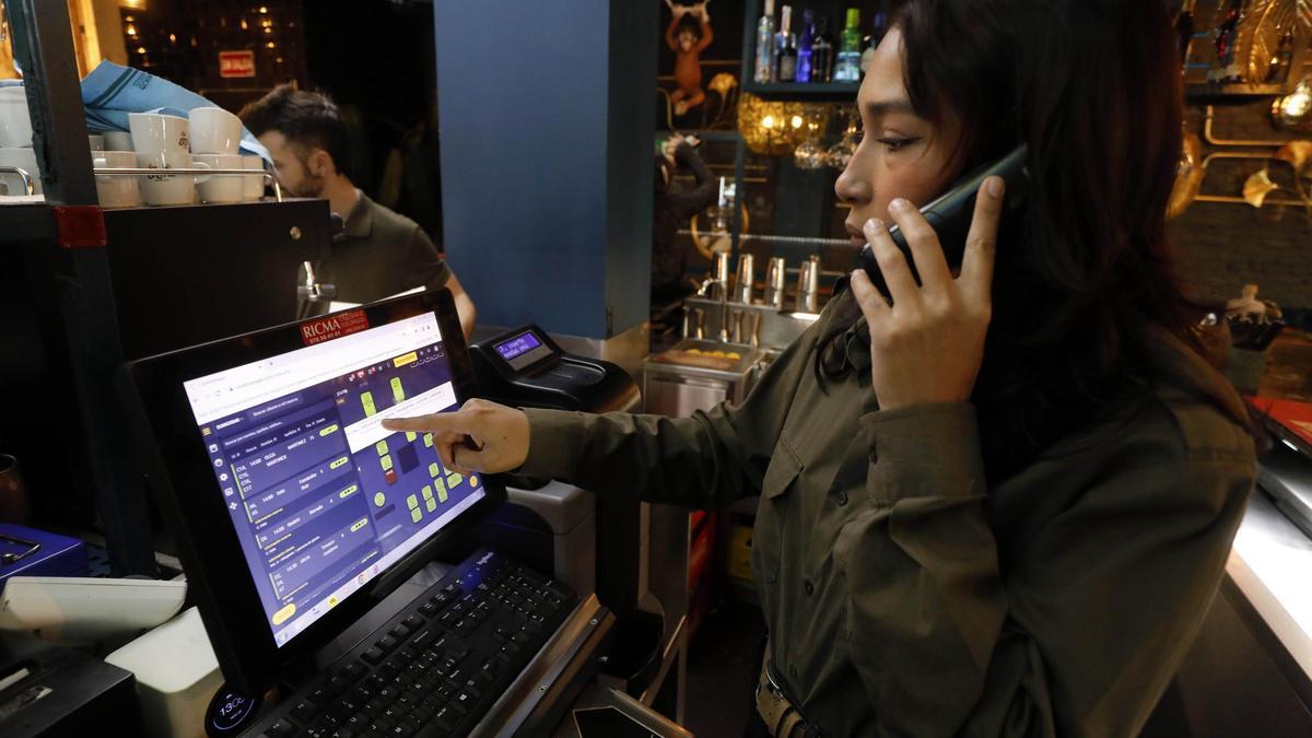 Una trabajadora del restaurante Bunkerbar de Zaragoza atiende una reserva por teléfono, este sábado.