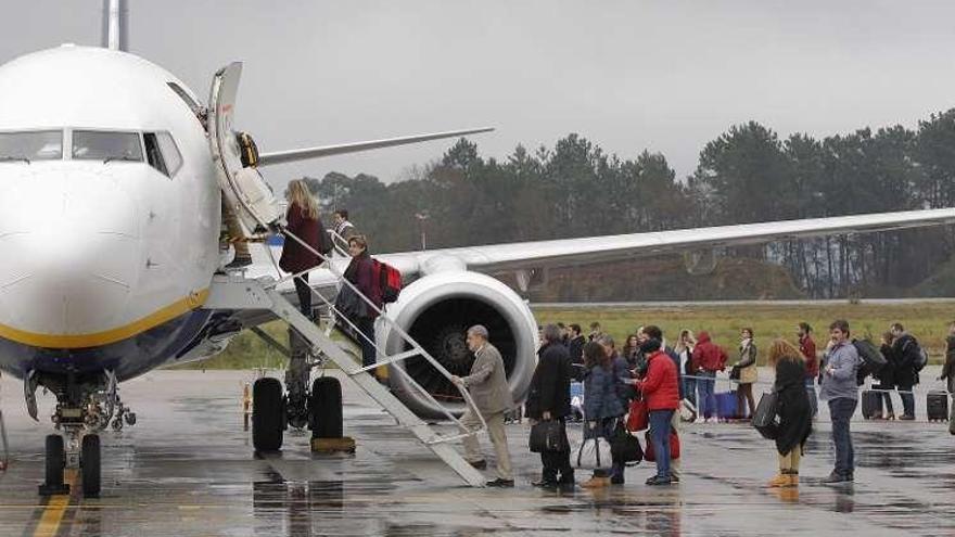 Pasajeros subiendo a un avión de Ryanair en la pista de Peinador. // José Lores