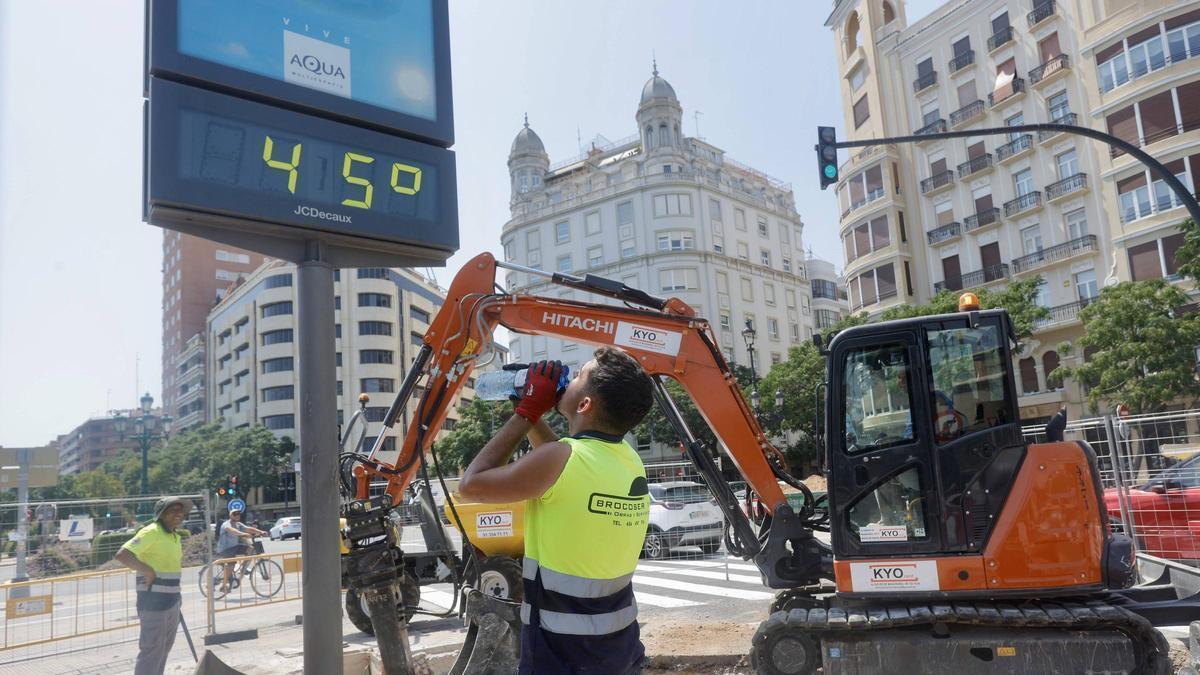 Un obrero bebe agua ante el intenso calor en València, en una imagen del verano pasado.