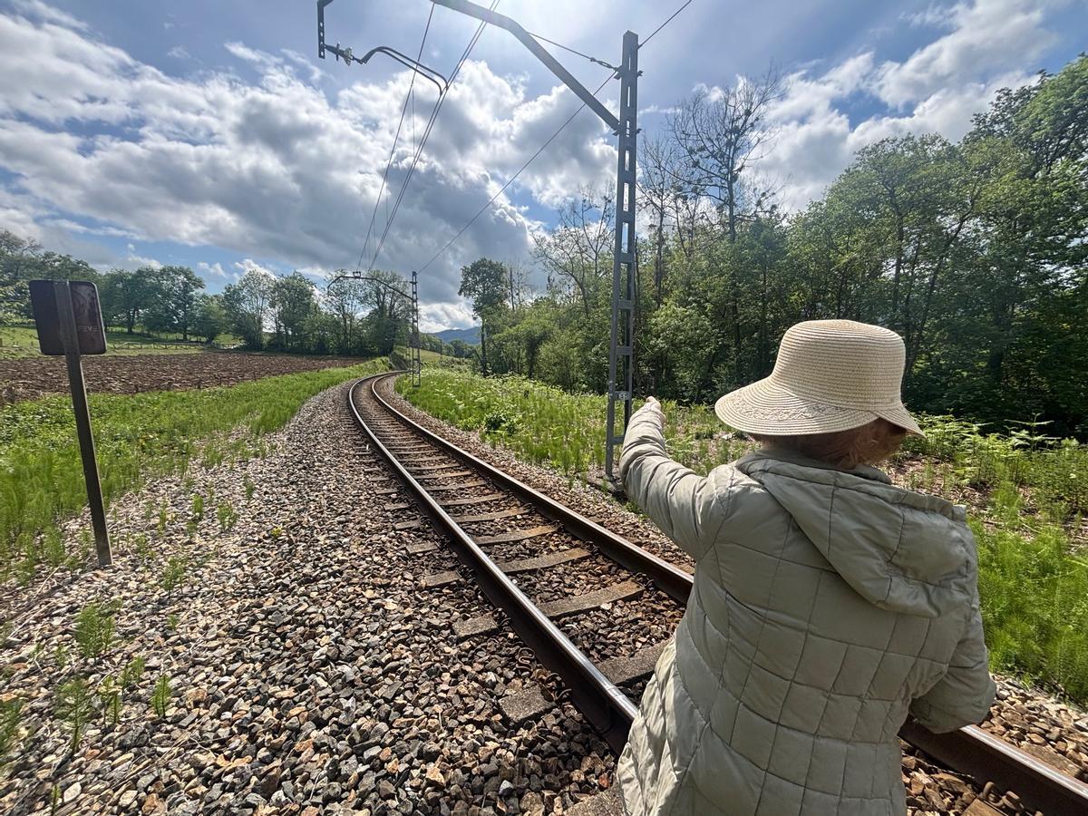 Una vecina señala la línea de Feve a su paso por Nava.