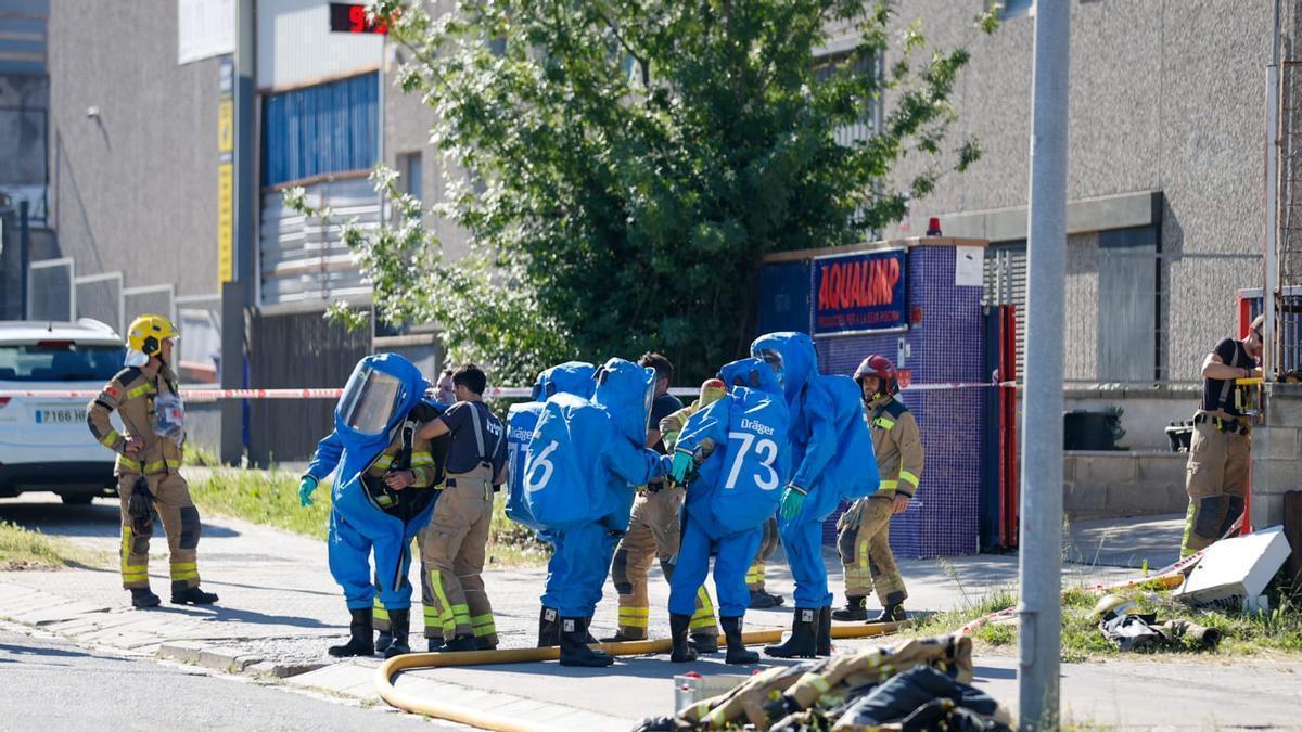 Bombers equipant-se amb els EPI de risc químic per treballar a la nau de Bufalvent