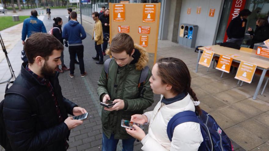 Estudiantes votando con su teléfono móvil en uno de los punto de información sobre el referéndum sobre la monarquía en la UPV.