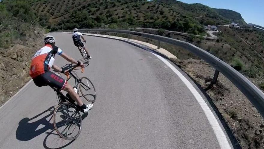 Dos ciclistas, por la carretera de las 7 revueltas, en las inmediaciones de la presa de Casasola.