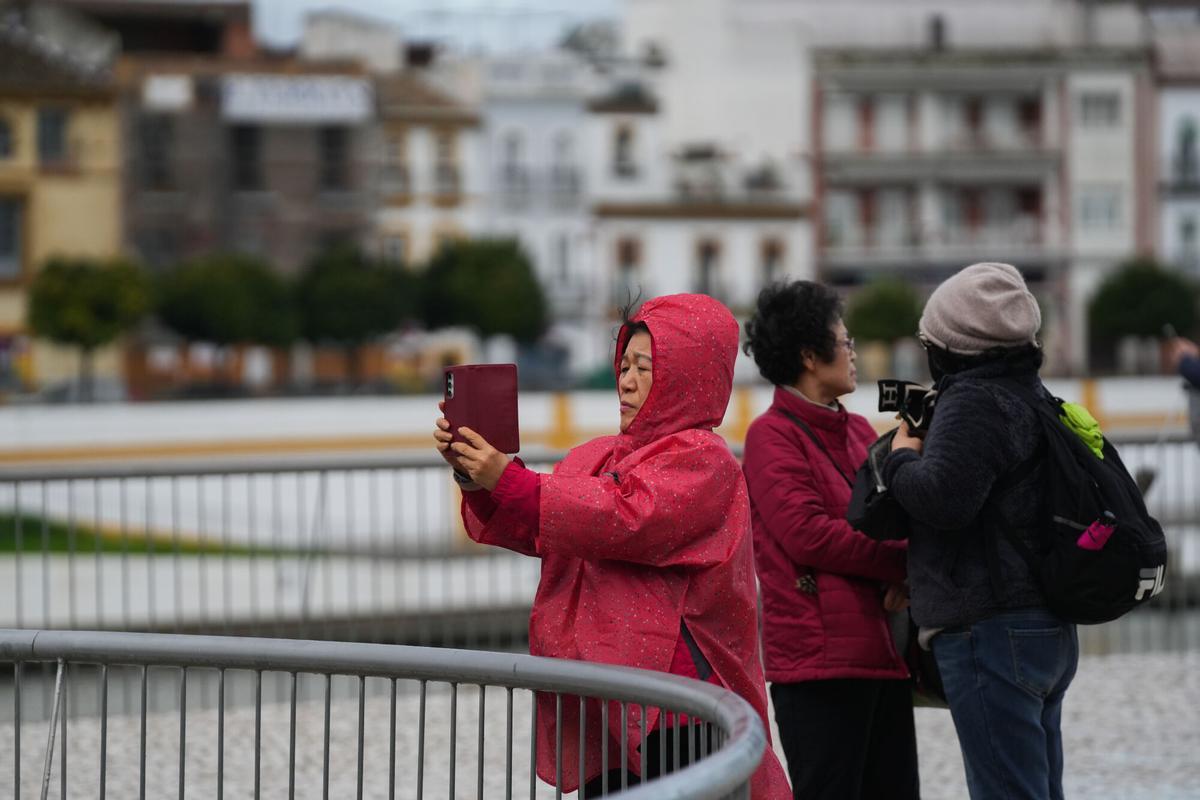 Turistas se protegen de la lluvia con impermeables, durante el paso de la borrasca Joseph.