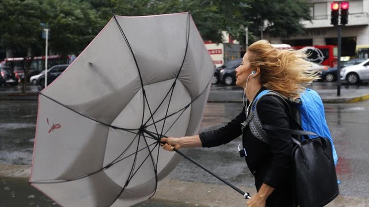 Una mujer sujeta su paraguas durante un temporal de lluvia y viento en Buenos Aires, este lunes.