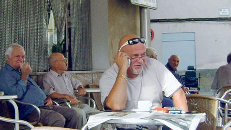 Un vecino de Maria habla por el móvil en la terraza de un bar de la localidad del Pla.