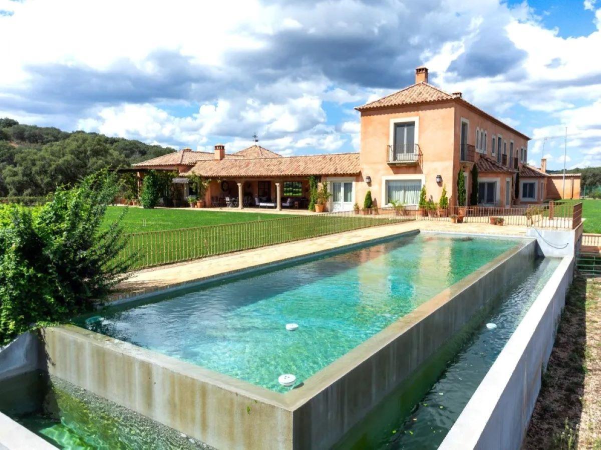 Imagen de la fachada del cortijo y la piscina.