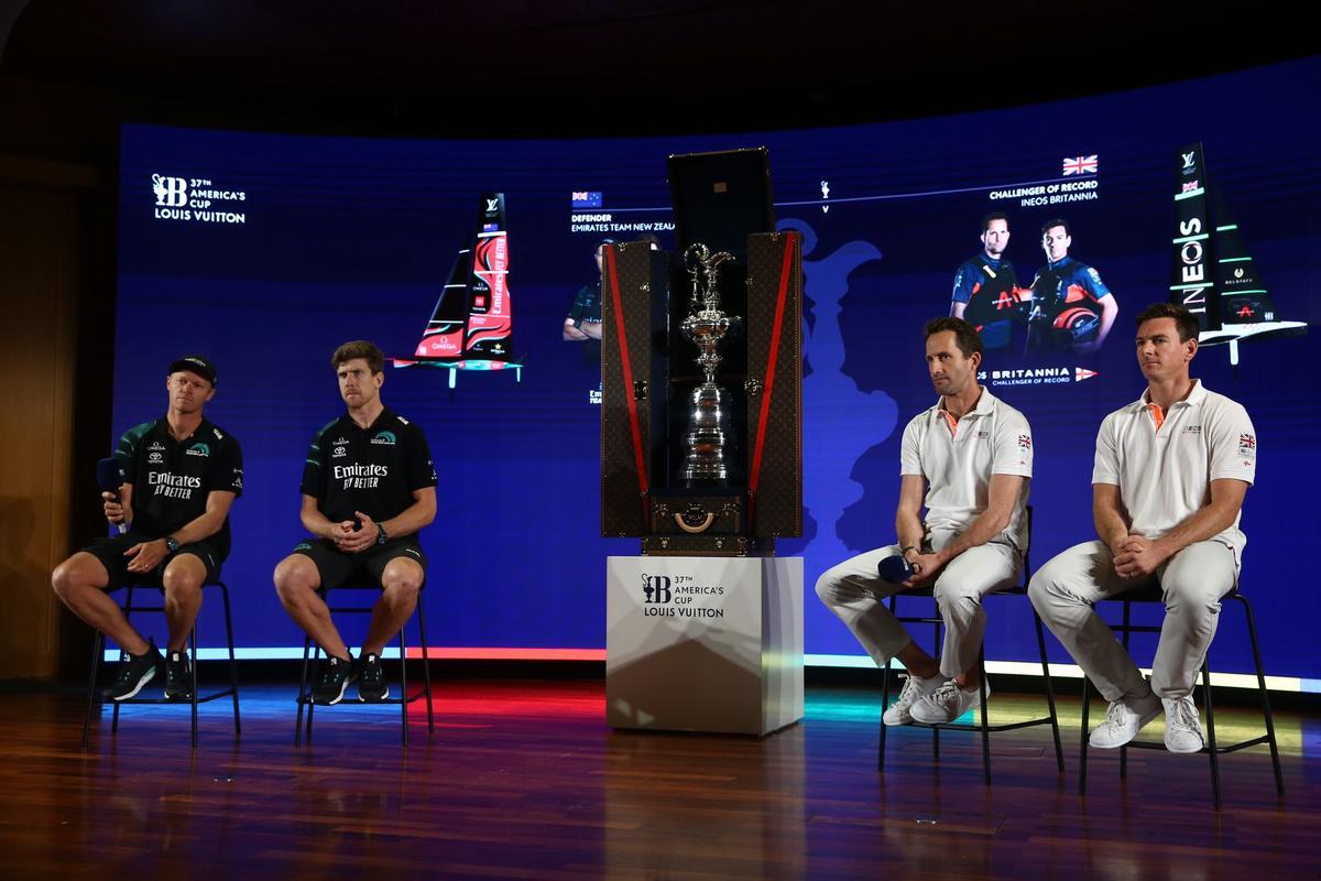 Los cuatro timoneles de Emirates Team New Zealand (izquierda) e Ineos Britannia que competirán en la final de la Copa América de vela, junto al trofeo.