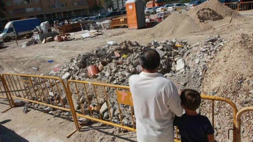 Un abuelo y su nieto contemplan el solar próximo a Villateresa, en San Blas, lleno de escombros.