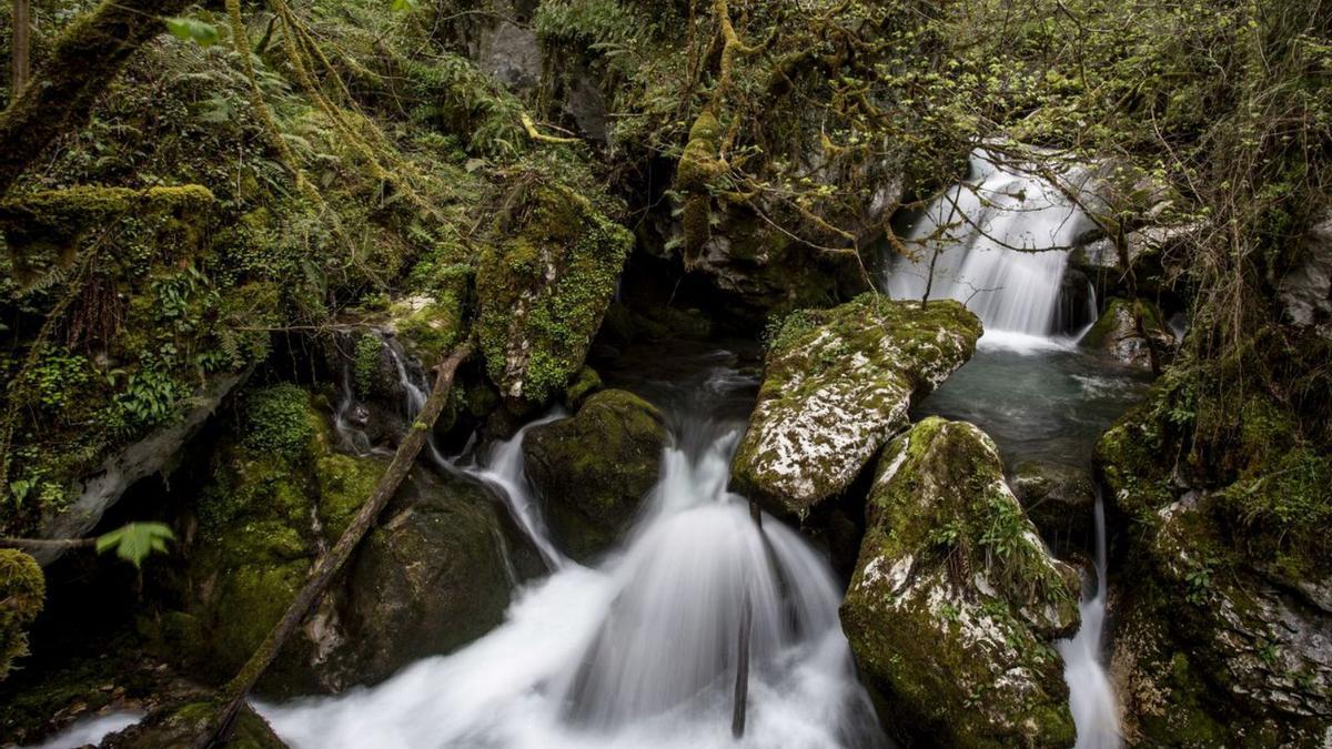 Cascada en el río Taranes y el edificio del Ayuntamiento de Ponga, en San Juan de Beleño.