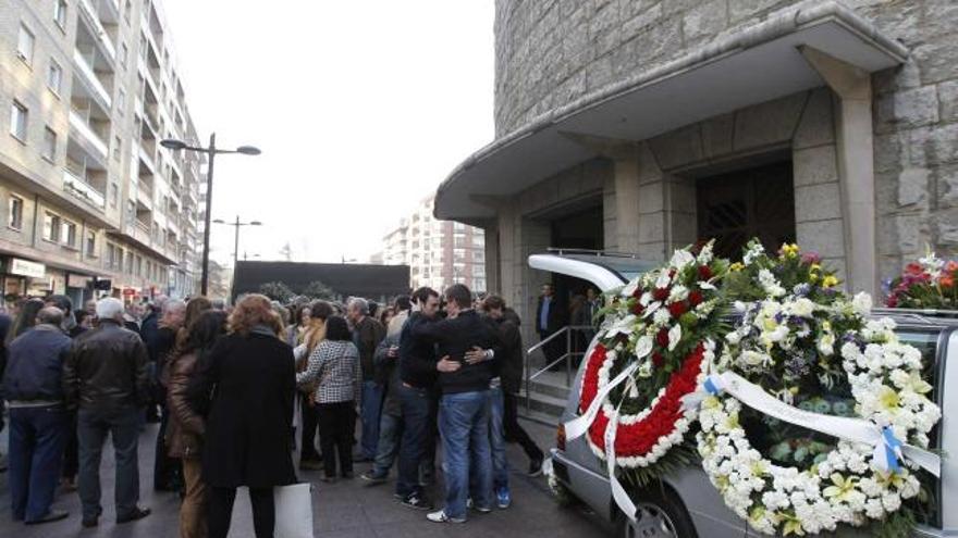 Nacho Felgueroso, de espaldas, al lado del coche fúnebre, recibe el pésame por el fallecimiento de su padre.