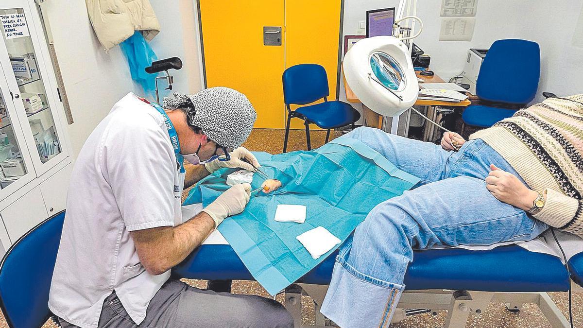 Un sanitario practica una intervención de cirugía menor en un centro de salud de Alicante.