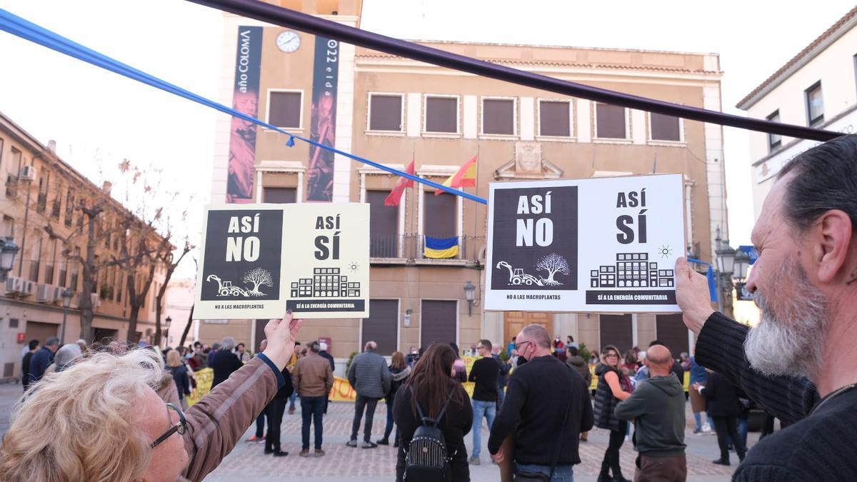 Dos manifestantes mostrando sus carteles frente al Ayuntamiento de Elda.