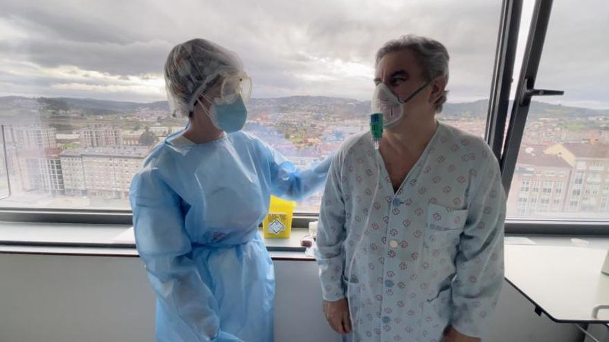 Una sanitaria y Celso Rodríguez en la habitación del hospital ourensano donde permanece pasando el coronavirus. |   // FDV