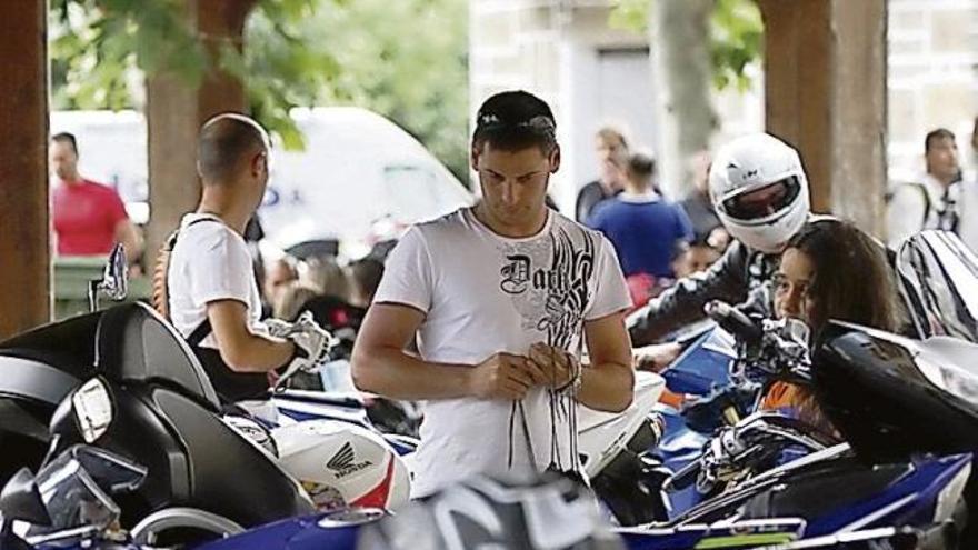 Varios jóvenes contemplan algunas de las motos estacionadas.