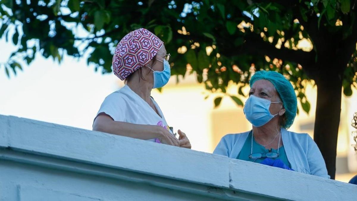 Dos sanitarias en el patio del Hospital con mascarillas para protegerse del coronavirus.